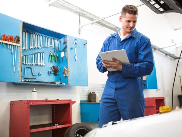 Mechanic examining under hood of car at the repair garage